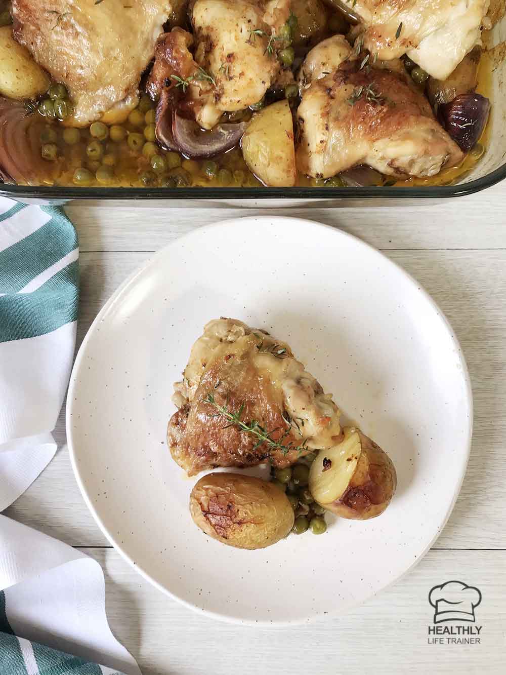 Chicken, potatoes and peas in a serving plate and a casserole dish is in the background.