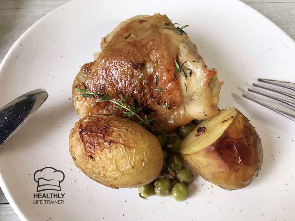Chicken, potatoes and peas in a serving plate.