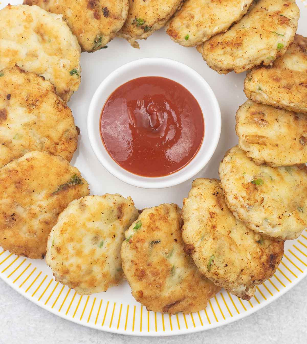 Fish patties (cakes) and a small bowl of ketchup.