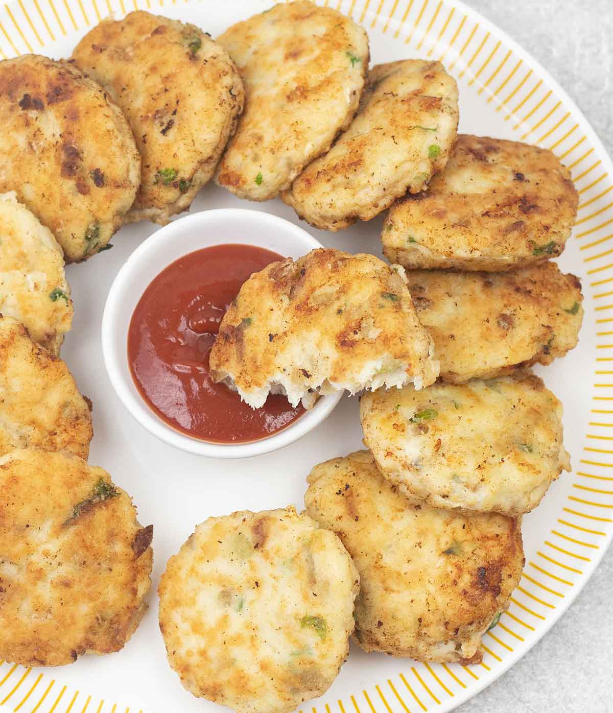 Fish patties (cakes) dipped in ketchup.