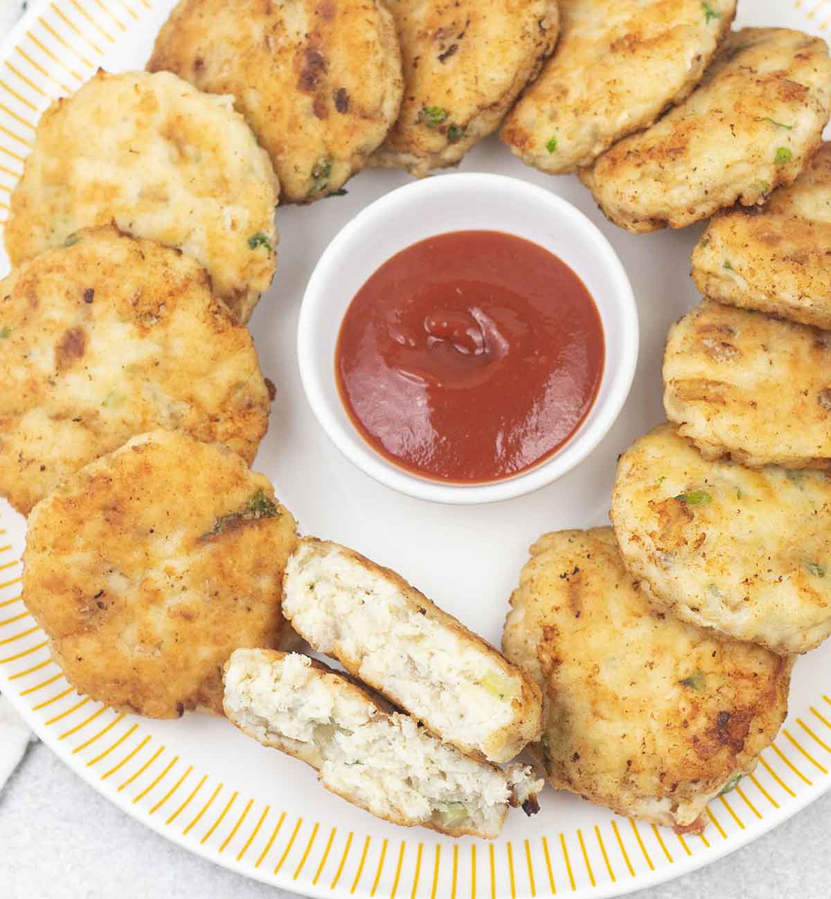 Fish patties (cakes) and a small bowl of ketchup.