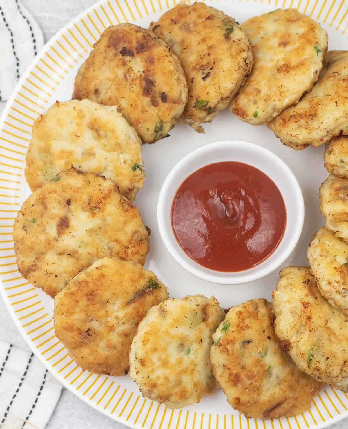 Fish patties (cakes) and a small bowl of ketchup.