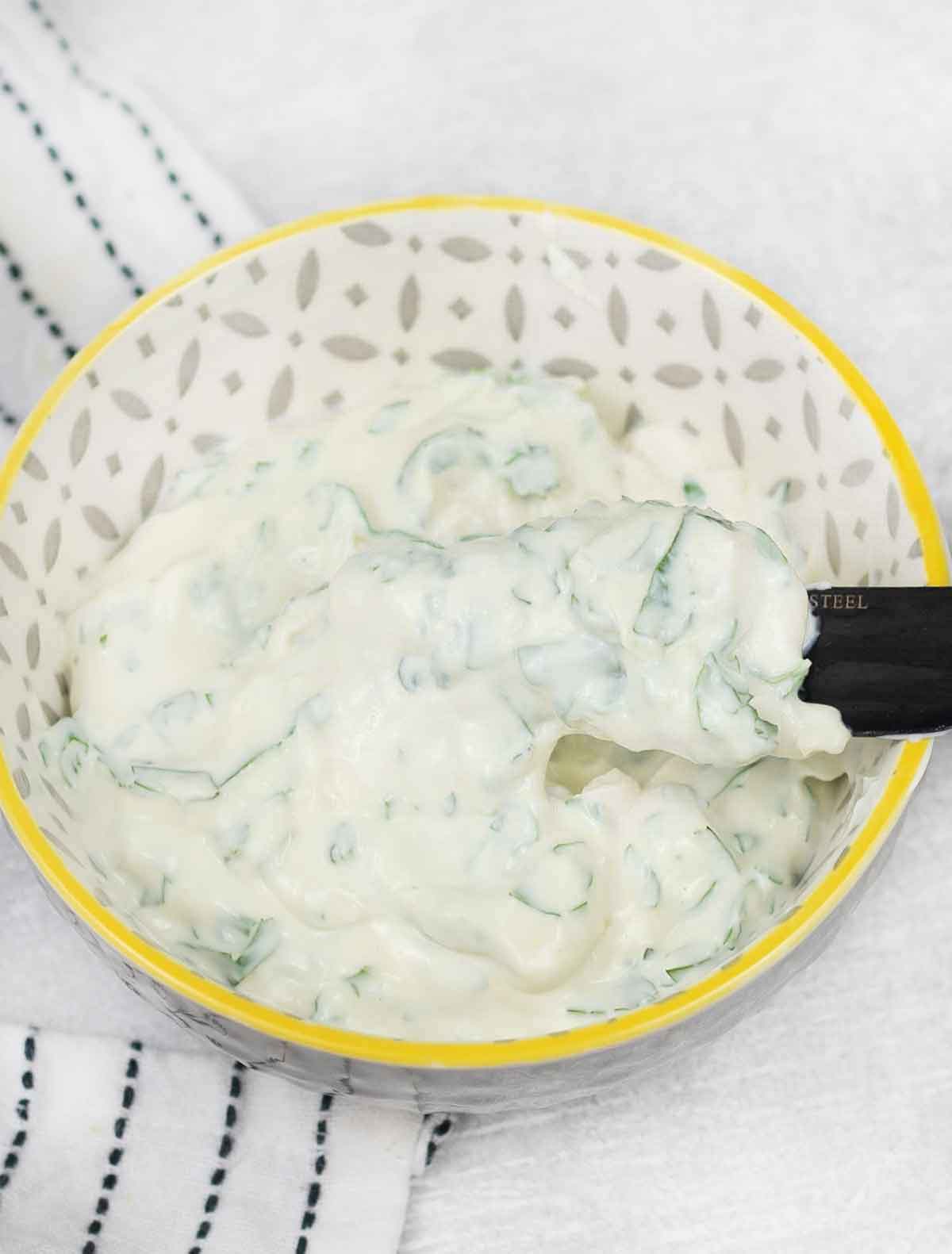 Garlic cilantro flavoured cream cheese in a bowl.