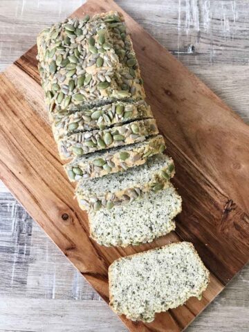 Keto 3 seed bread slices are on a chopping board.