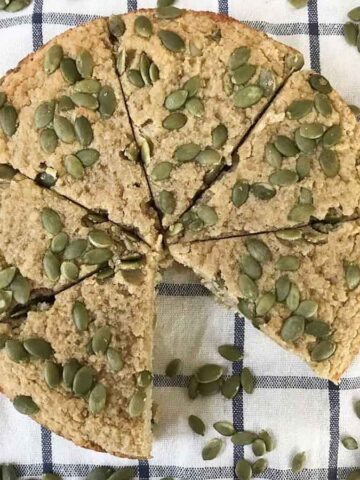 pumpkin cake with almond flour topped with pumpkin seeds.