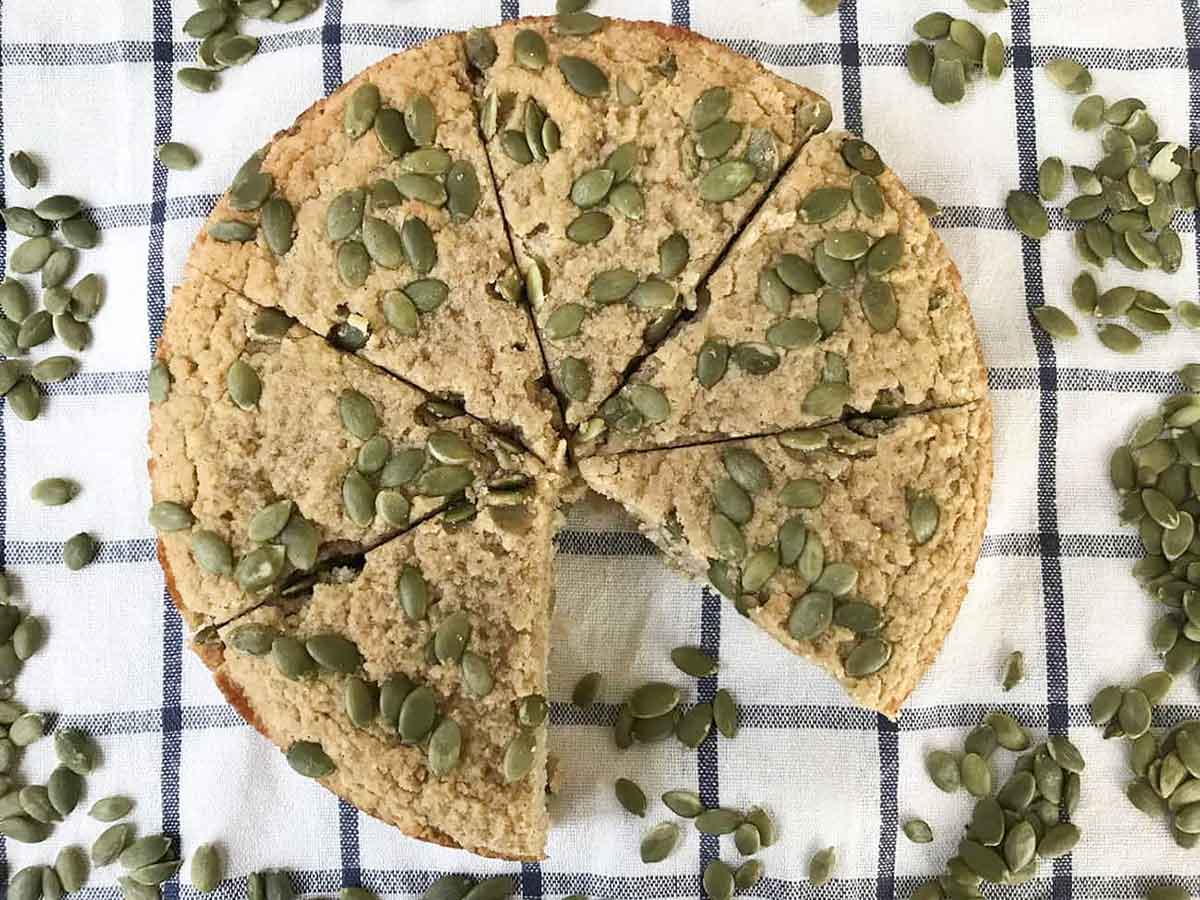 pumpkin cake with almond flour topped with pumpkin seeds.