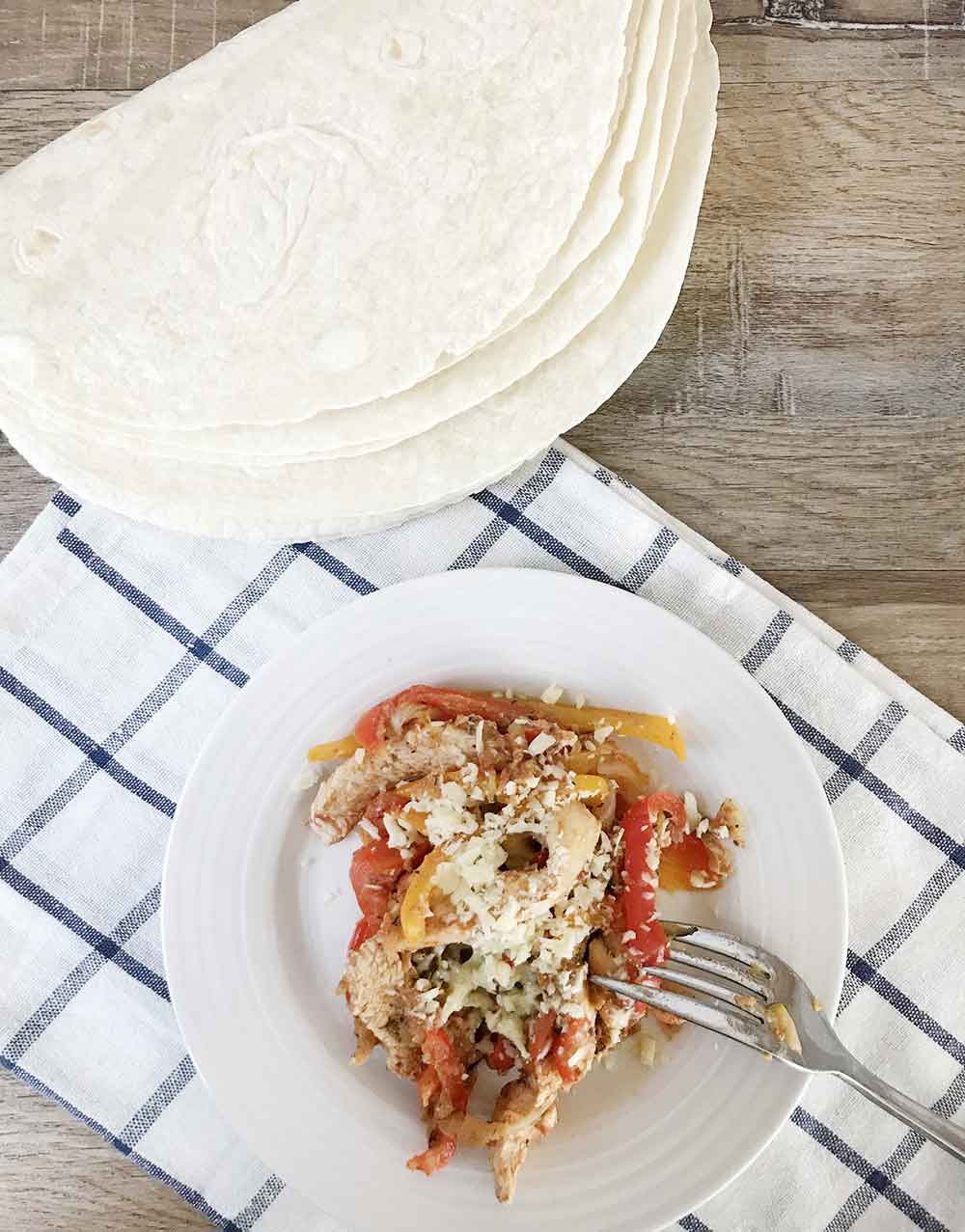 one pan chili chicken fajitas in a plate topped with cheese.