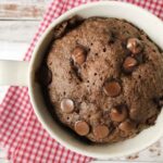 keto almond flour chocolate mug cake topped with chocolate chips.