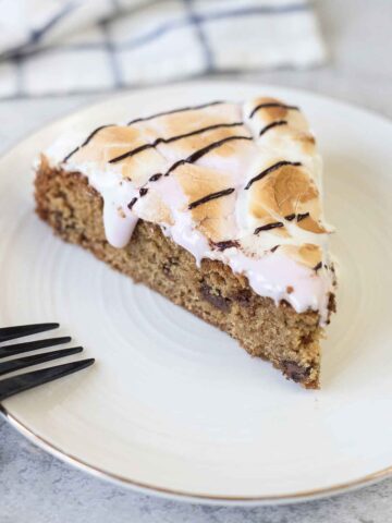 S'mores cookie cake slice topped with melted marshmallows.