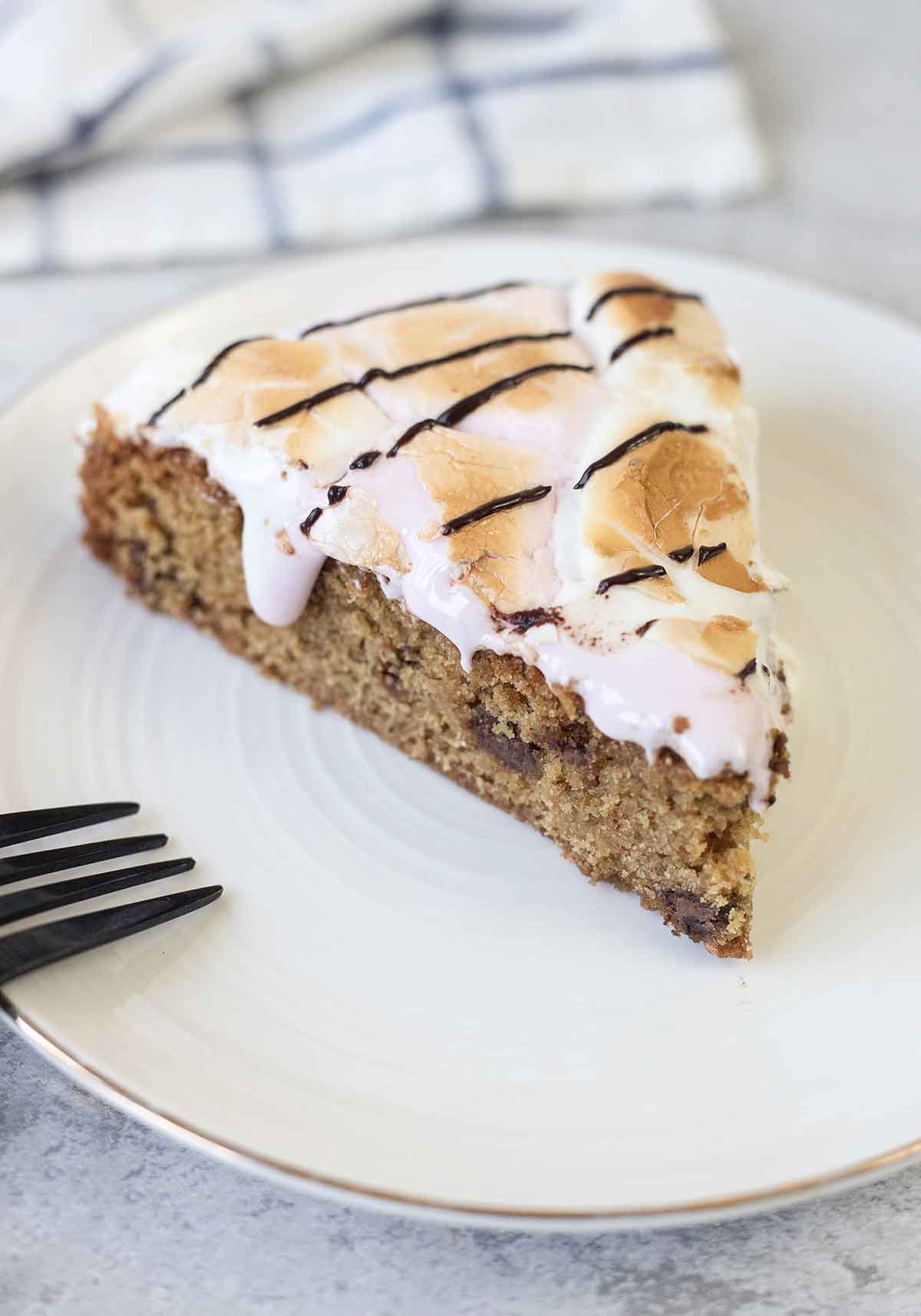 S'mores cookie cake slice topped with melted marshmallows.