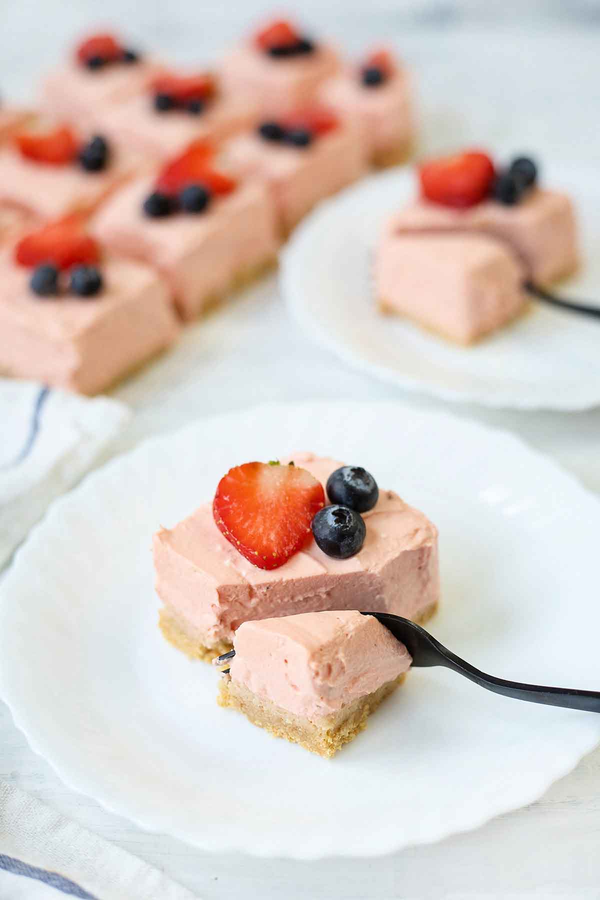 Cut no bake Philadelphia strawberry cheesecake bar with fork.