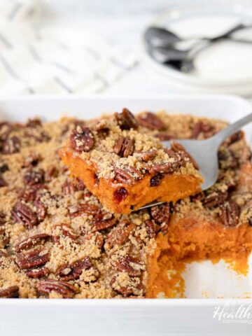 Cut a slice of the old fashioned sweet potato casserole topped with pecans.