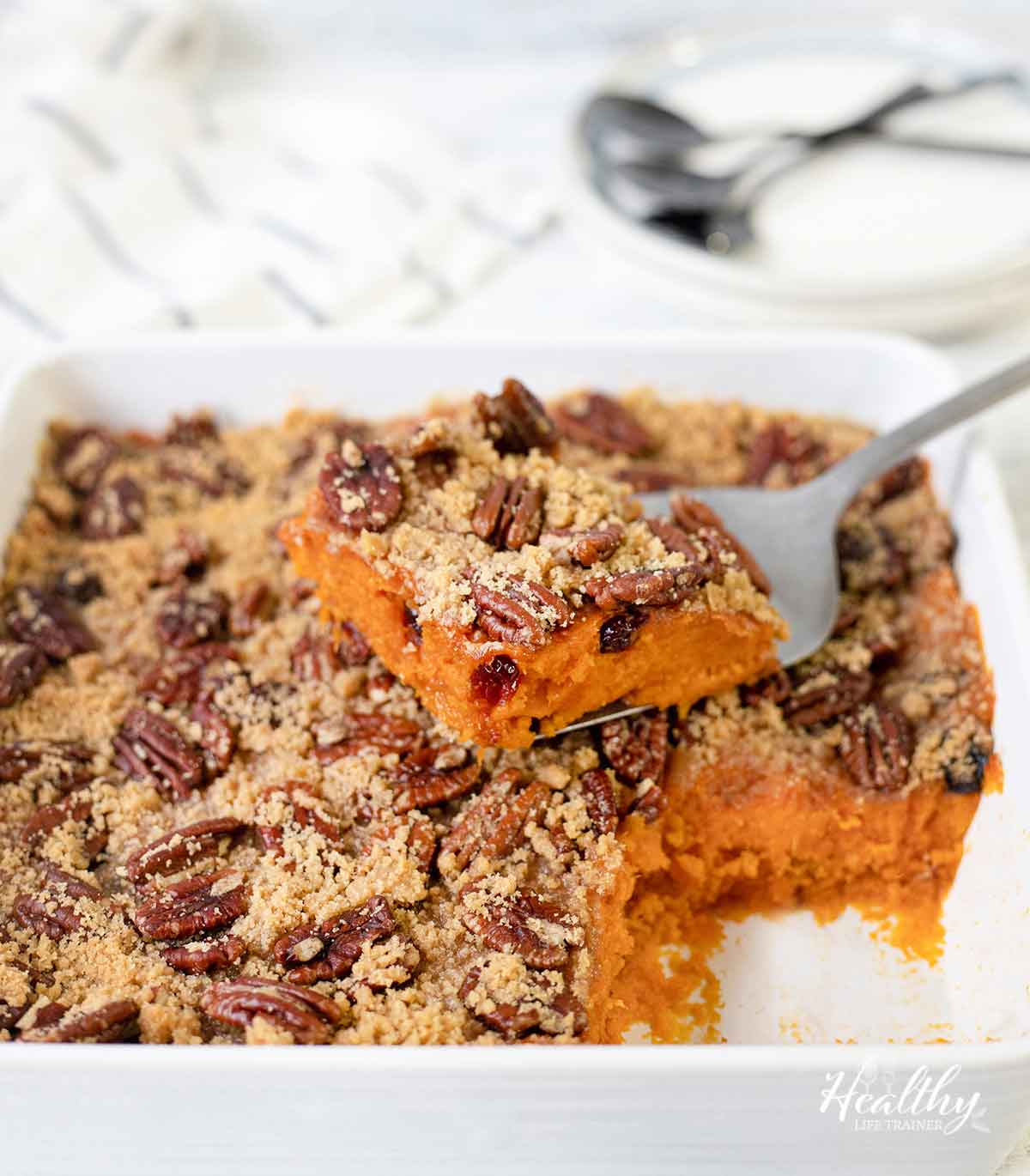 Cut a slice of the old fashioned sweet potato casserole topped with pecans.