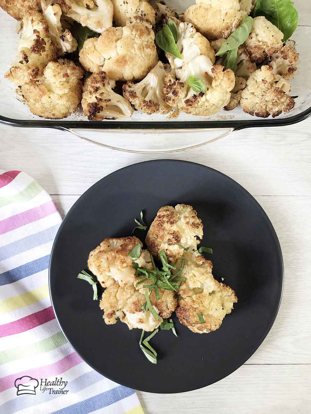 Vegan roasted cauliflower with garlic in a serving plate.