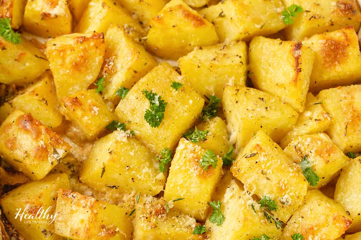 close up of roasted garlic parmesan potatoes topped with fresh herbs.