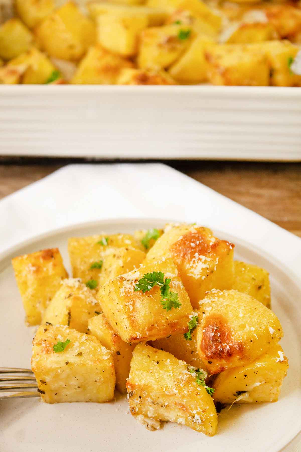 a plate with herb roasted potatoes garnished with fresh herbs.