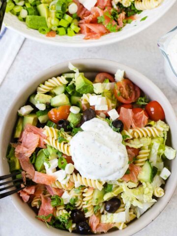 smoked salmon pasta salad topped with creamy salad dressing.