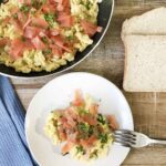 scrambled eggs and smoked salmon topped with chopped parsley.