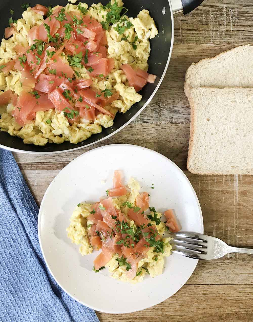 scrambled eggs and smoked salmon topped with chopped parsley.