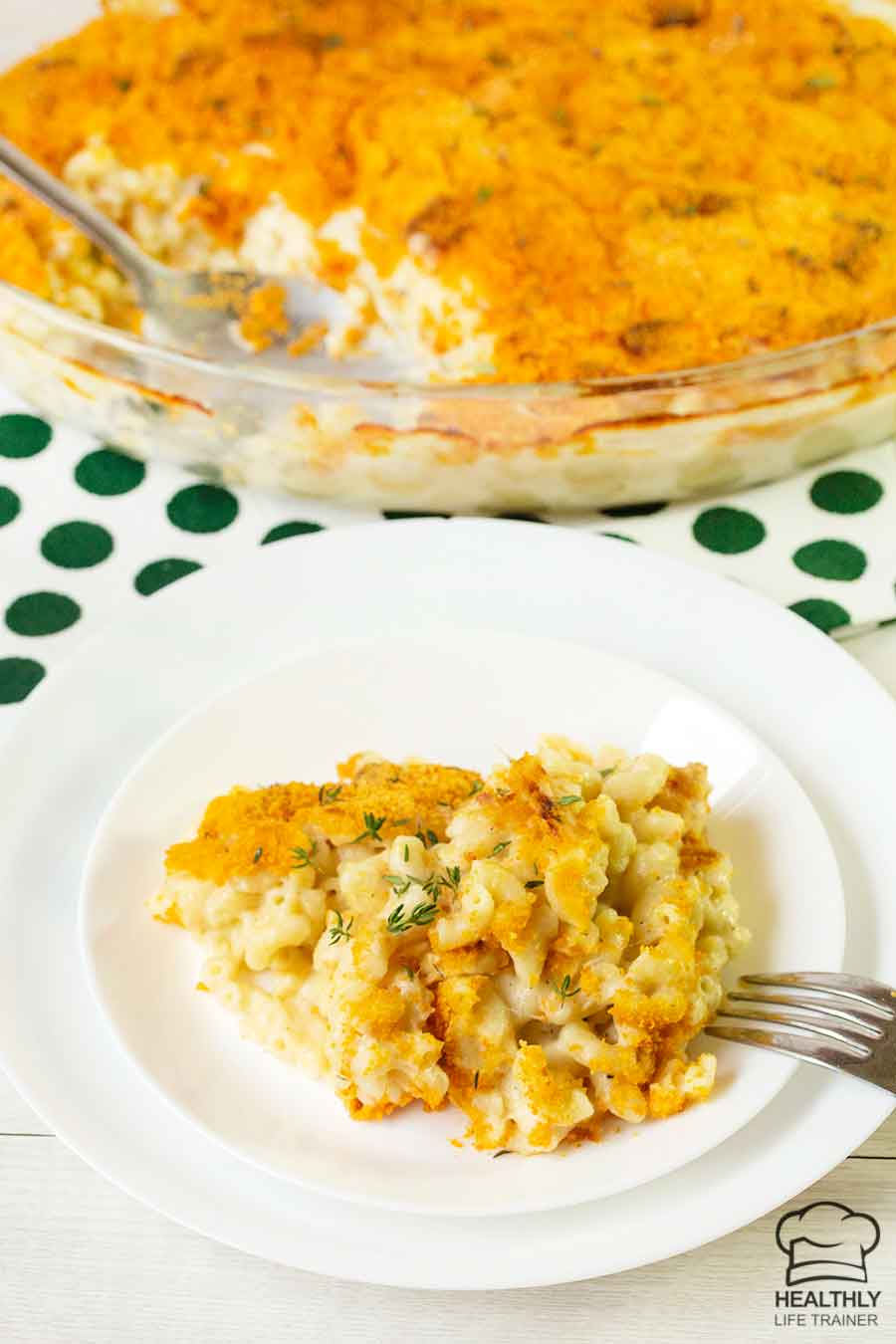 Old fashioned baked macaroni and cheese on a plate and the whole casserole is in the background.