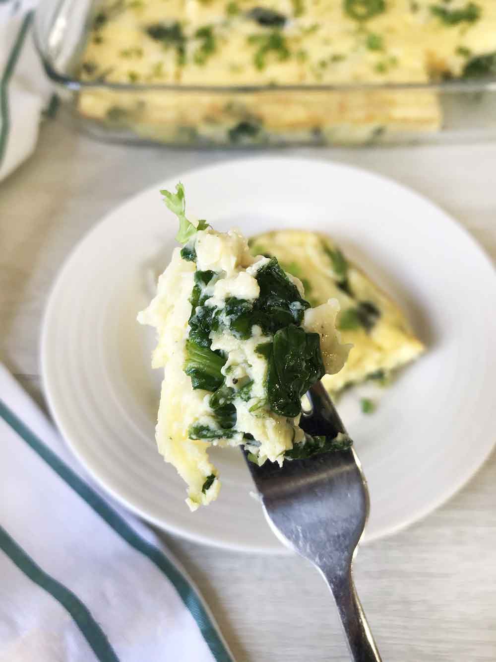 A forkful of crustless spinach quiche.