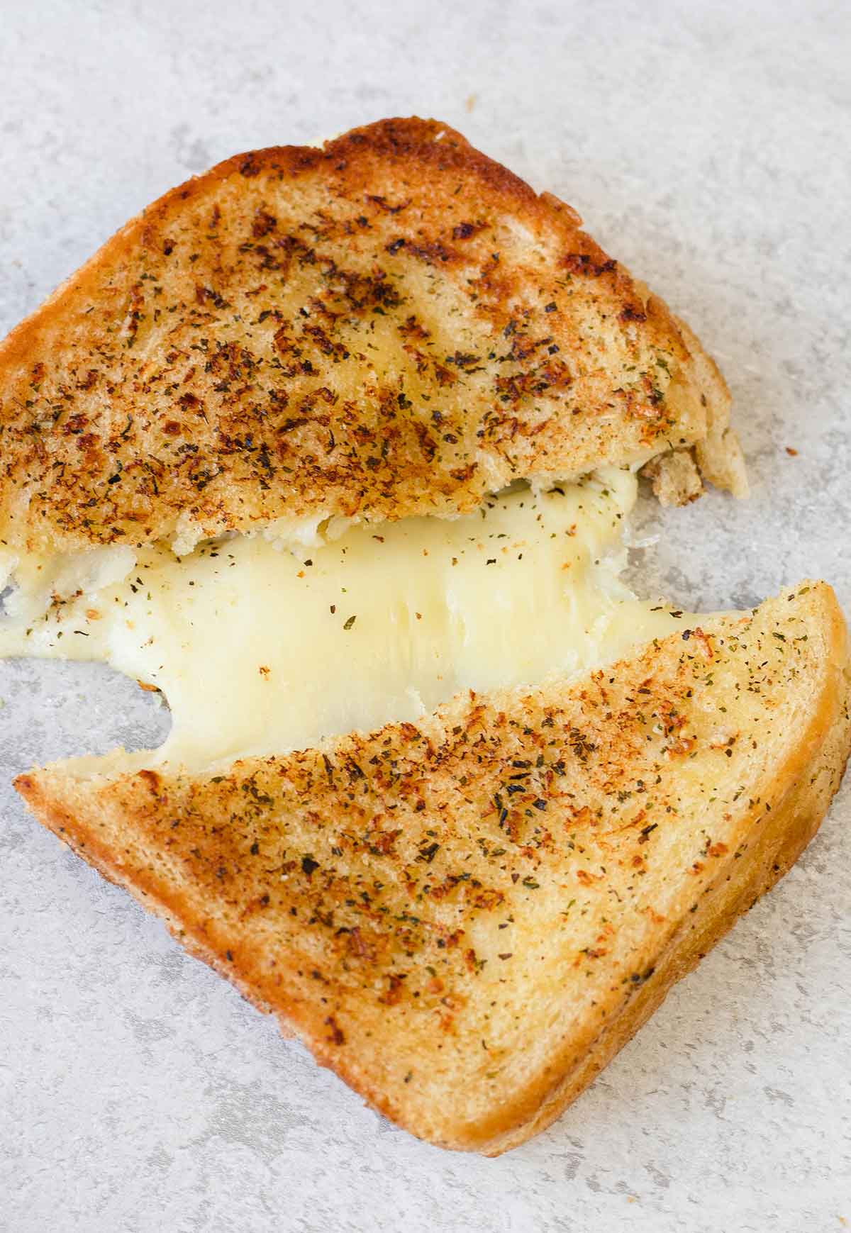 Cut the garlic bread grilled cheese sandwich into halves.