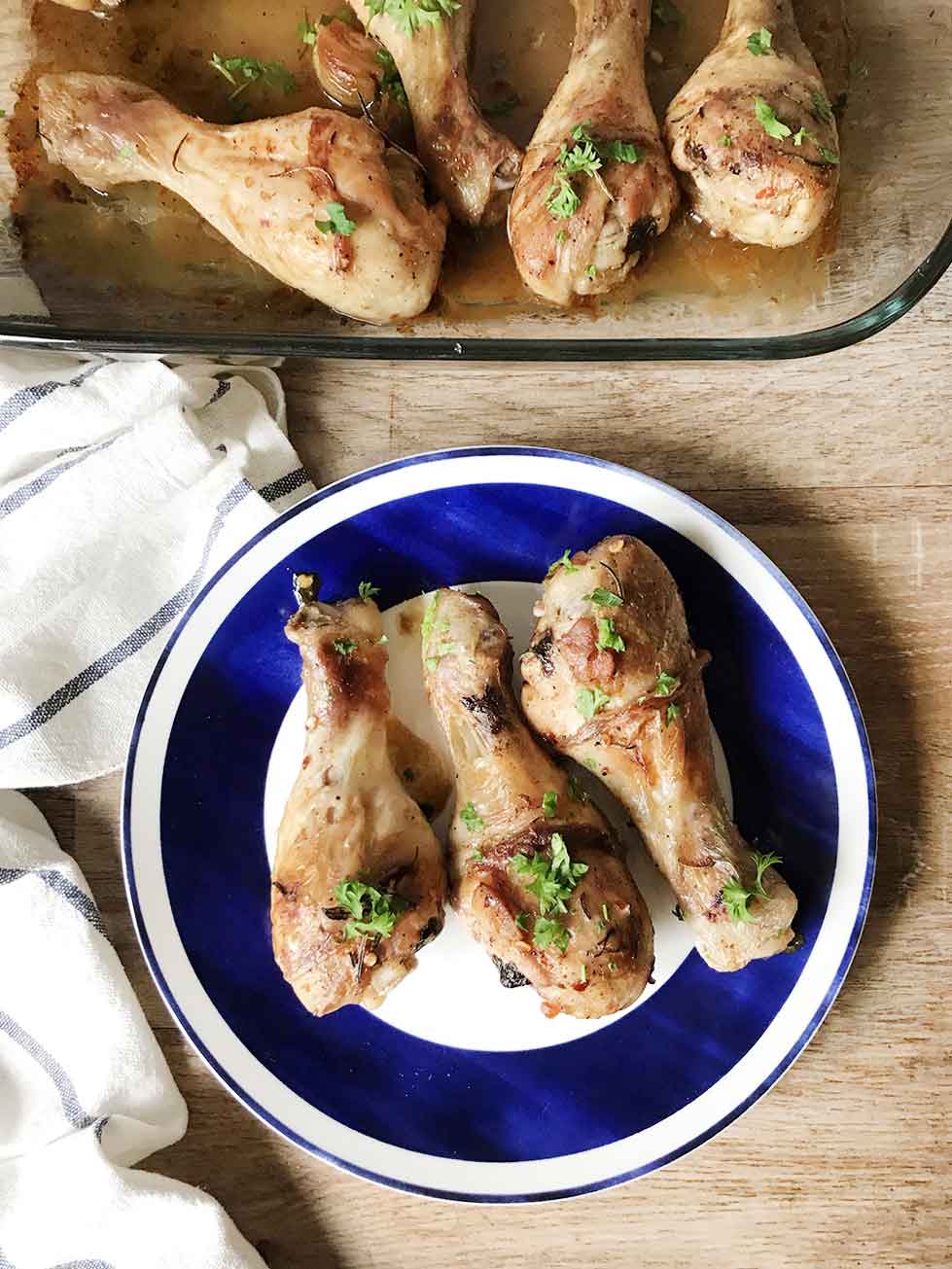 Garlic lemon baked chicken drumsticks in a serving plate.