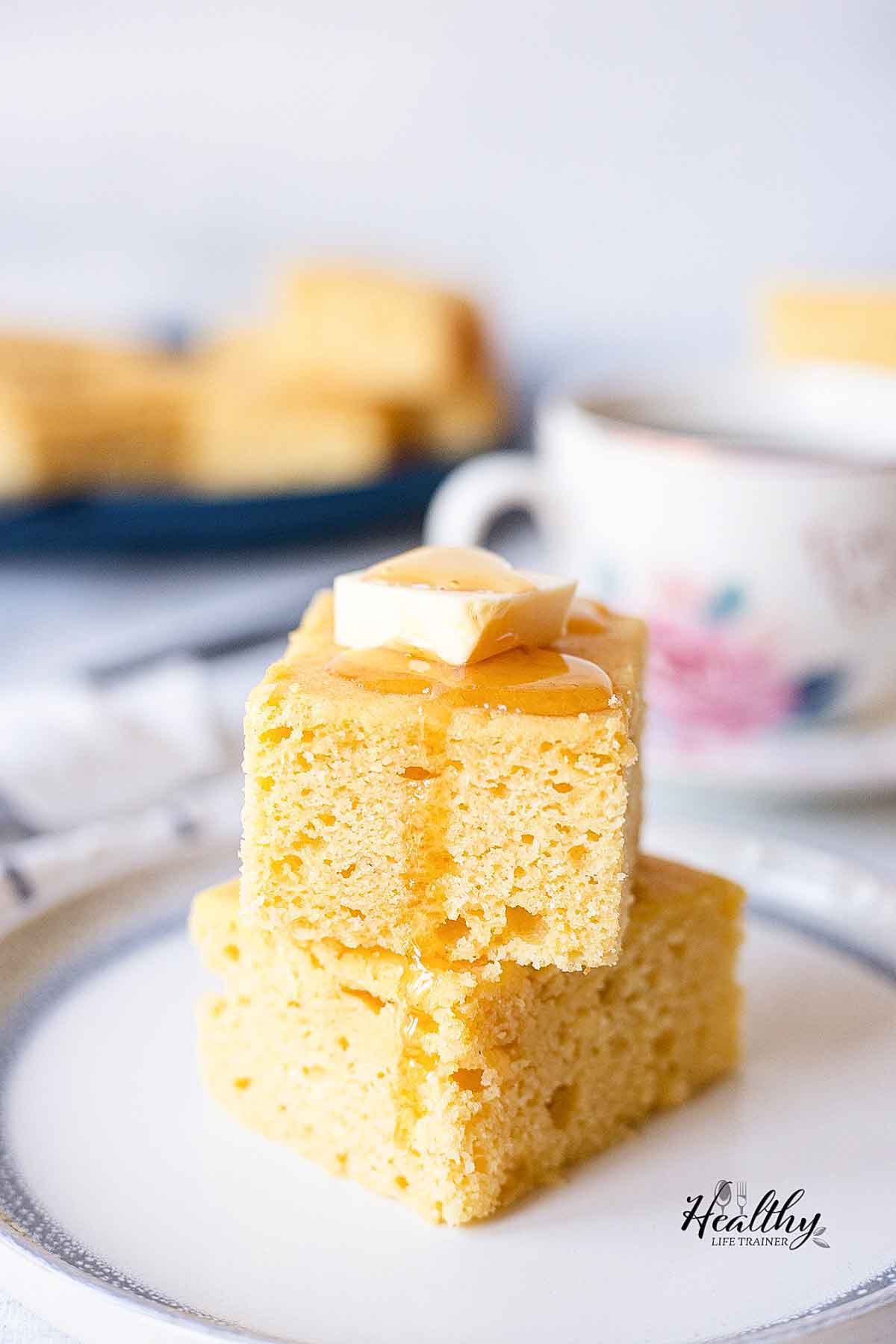 Close shot to a cornbread cake slice drizzled with honey.