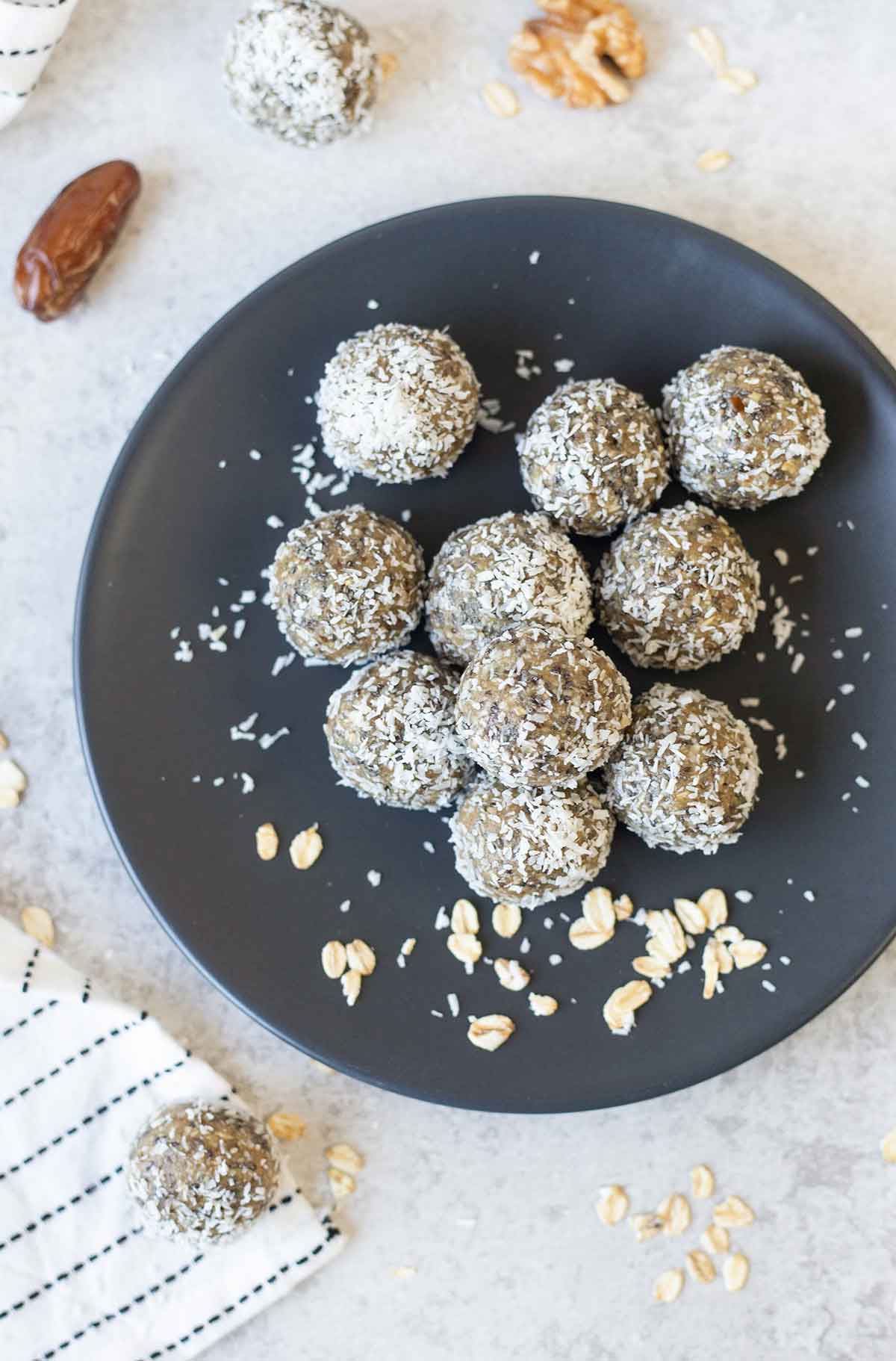 Date energy balls rolled in shredded coconut and a bowl of hazelnuts.