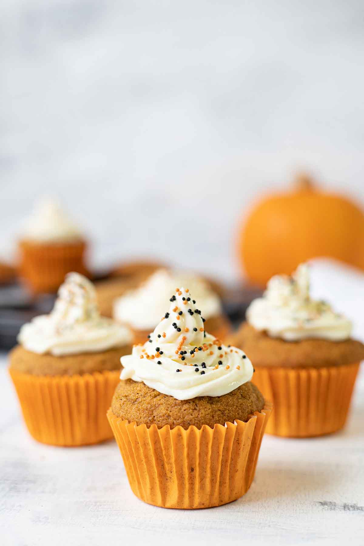 Close up shot to a pumpkin spice cupcake topped with cream cheese frosting.