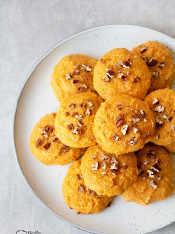 Sweet potato cookies in a serving plate topped with chopped pecan.