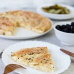 A side shot of a slice of the Greek cheese pie (tiropita) showing the cheese inside.