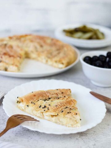 A side shot of a slice of the Greek cheese pie (tiropita) showing the cheese inside.