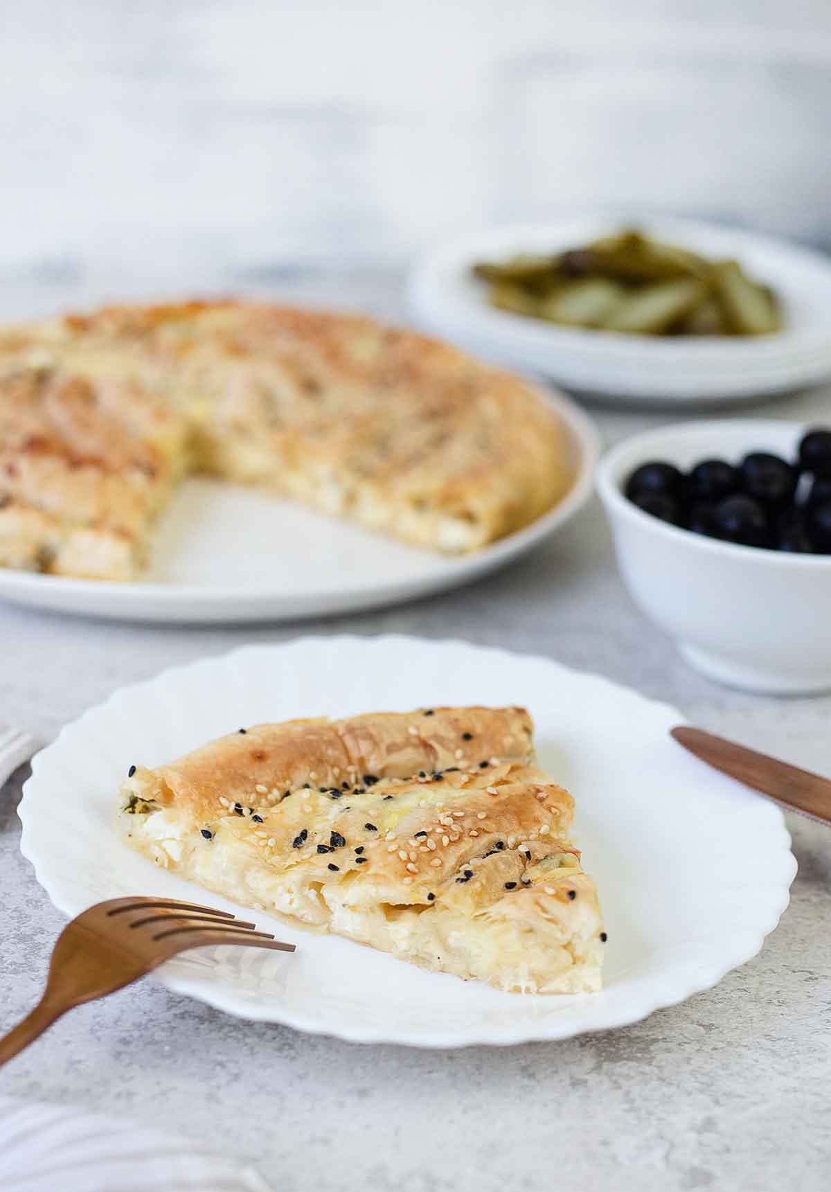 A side shot of a slice of the Greek cheese pie (tiropita) showing the cheese inside.