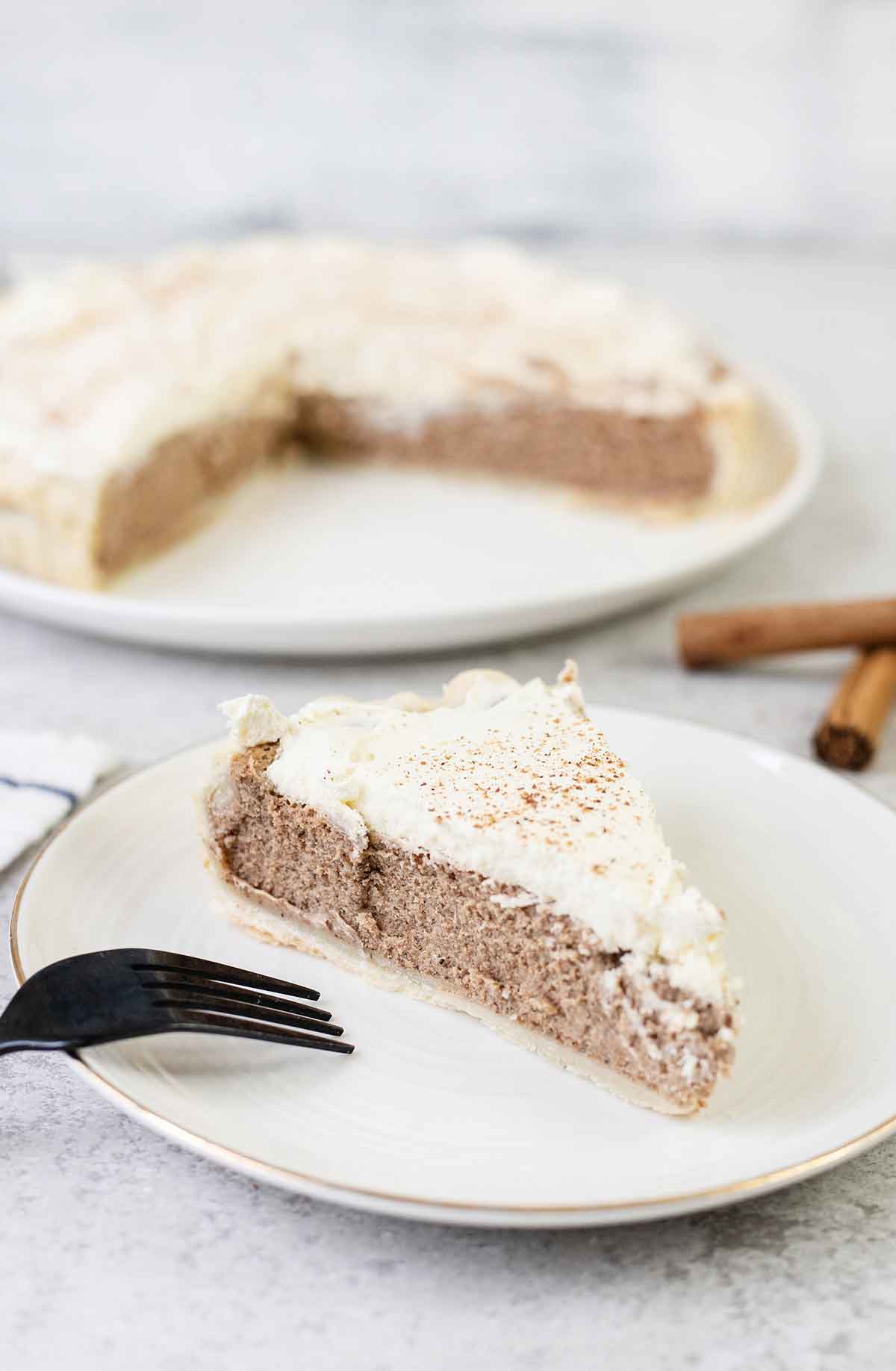 cinnamon pie slice and 2 cinnamon quills in the background.