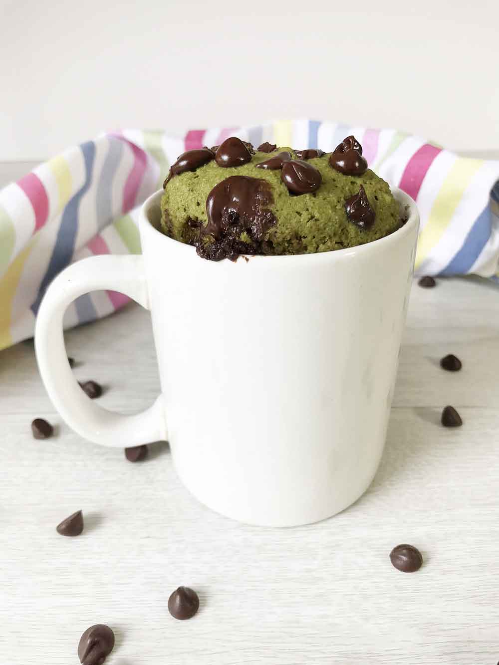 keto matcha mug cake and some unsweetened chocolate chips around.