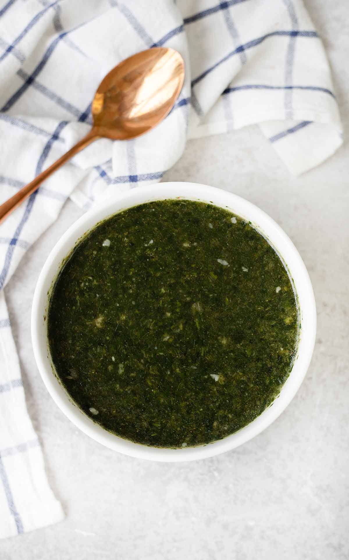 The green soup (Molokhia) in a bowl and a spoon is in the background.