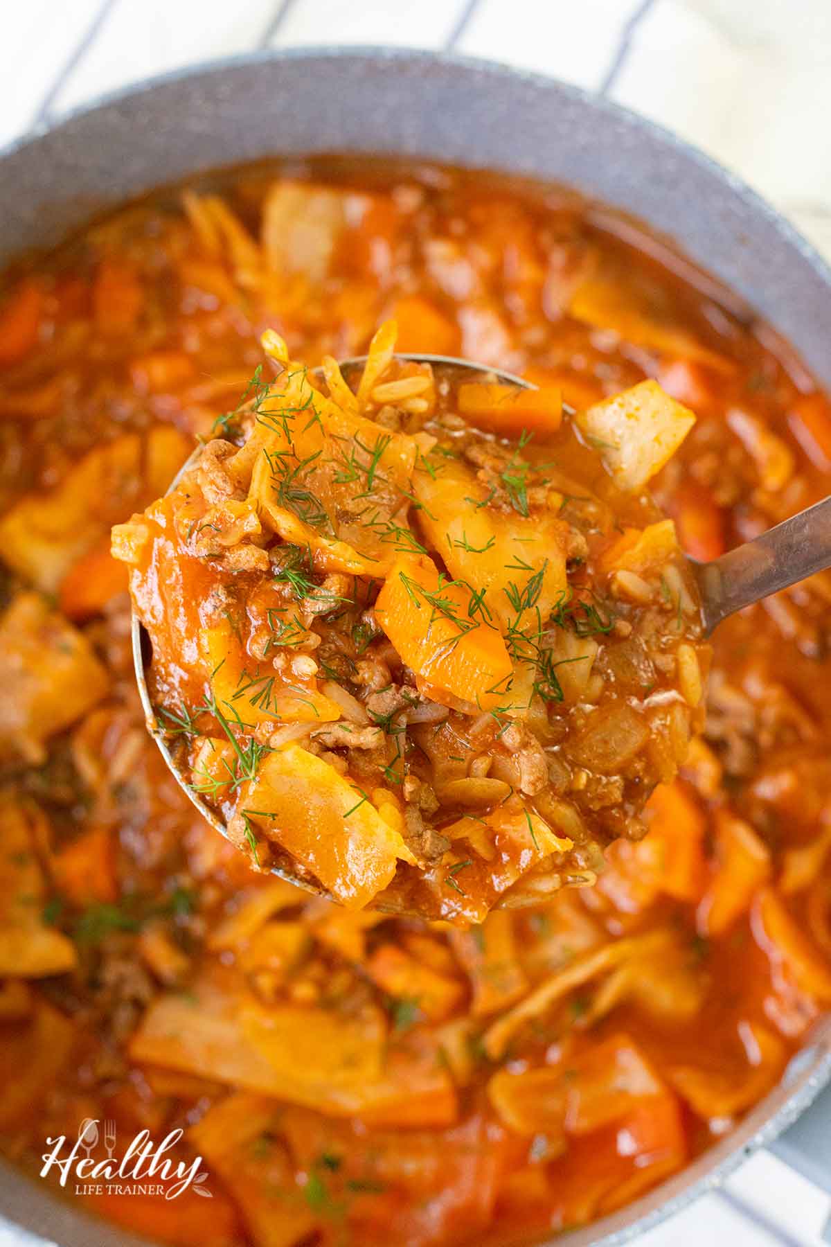 Scooping the cabbage roll soup with a ladle.