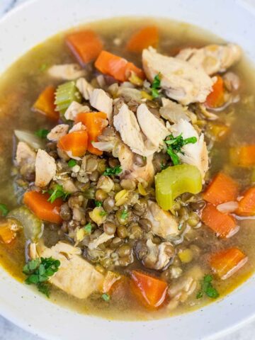 chicken lentil soup with celery and carrot in a bowl.