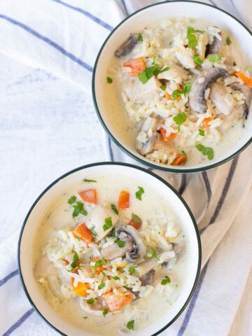 2 bowls filled with creamy chicken and rice soup.
