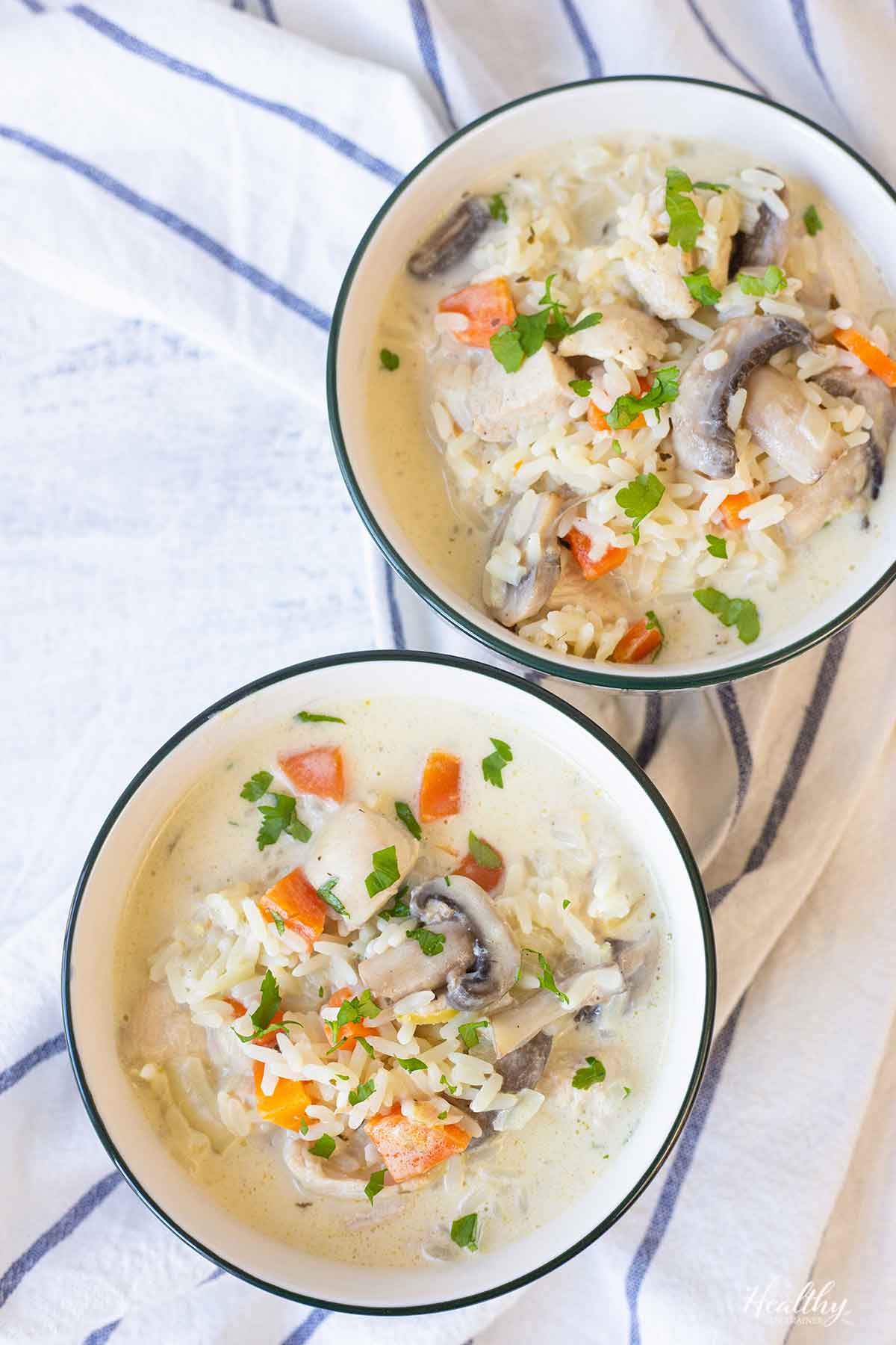 2 bowls filled with creamy chicken and rice soup.