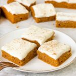 Pumpkin Squares in a plate topped with Cream Cheese Frosting.
