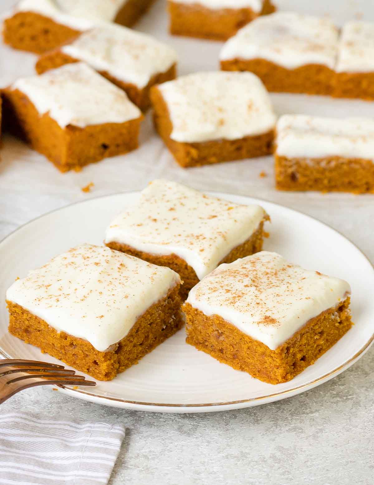 Pumpkin Squares in a plate topped with Cream Cheese Frosting.