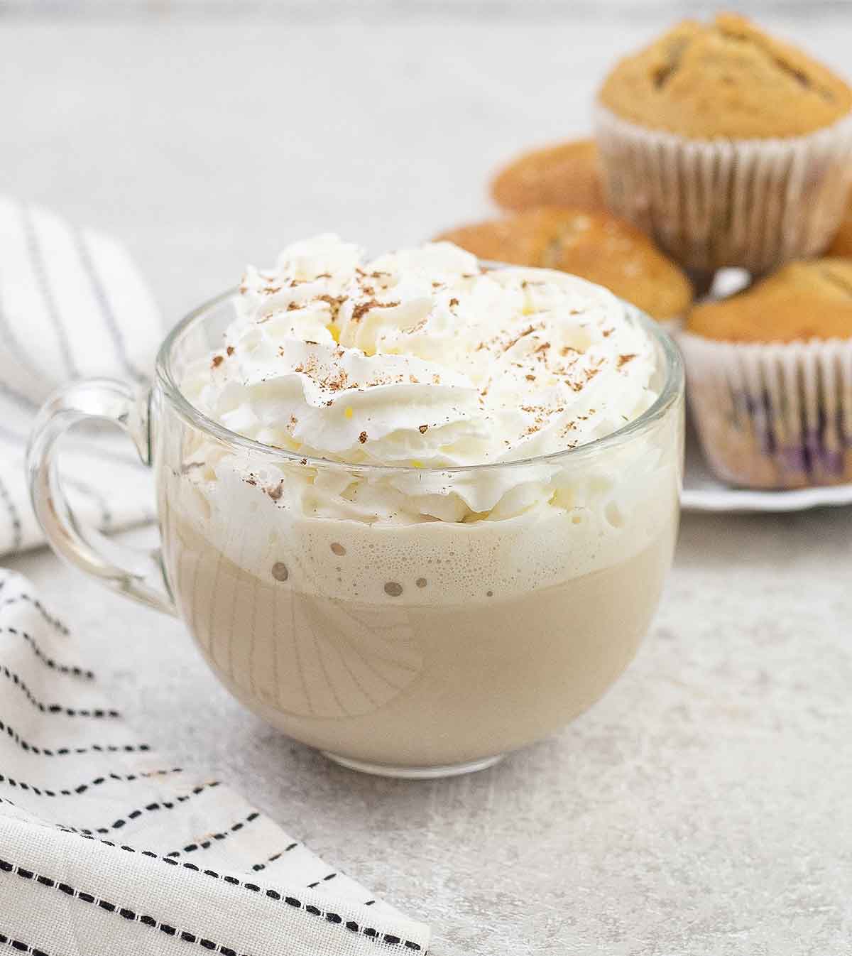 Cup of white chocolate latte topped with whipped cream.