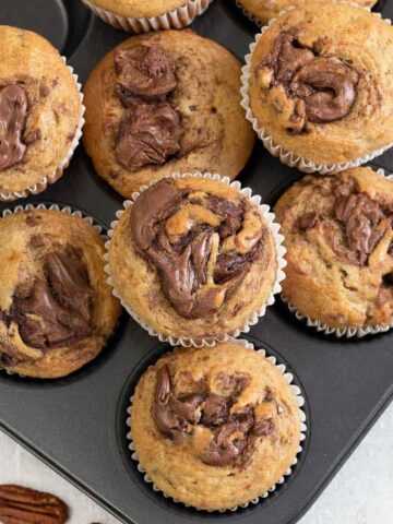 Nutella swirl banana Muffins in a muffin tin.