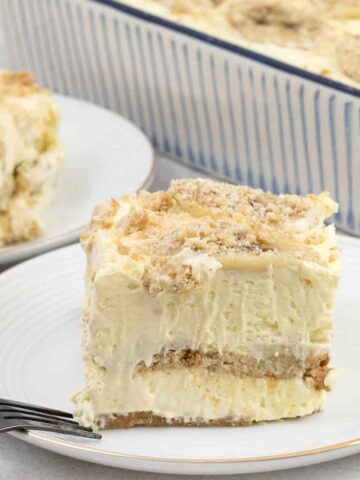 Banana pudding lasagna topped with fresh slices of banana and biscuit crumbs.