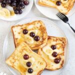 Buttermilk French Toast topped with grapes and banana slices.