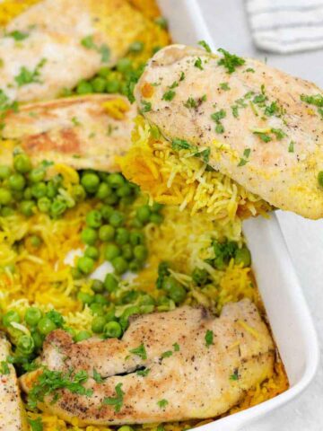 Chicken and Yellow Rice with peas in a casserole pan.