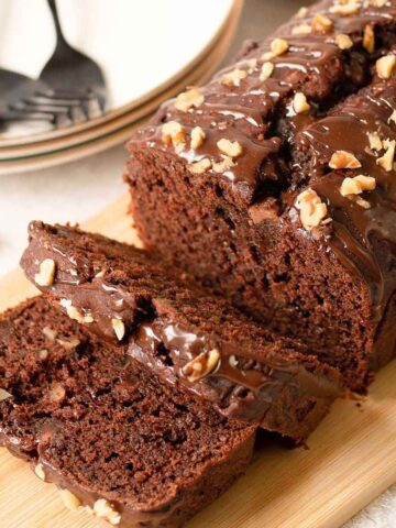 Chocolate banana bread drizzled with melted chocolate and topped with walnuts.