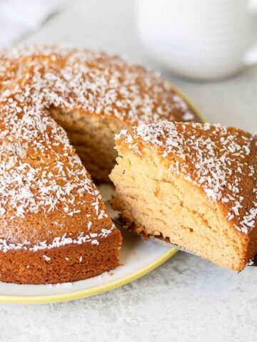 Golden Syrup Cake slice topped with shredded coconut.